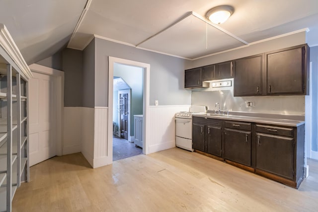 kitchen with a wainscoted wall, light wood-style flooring, white range oven, light countertops, and a sink