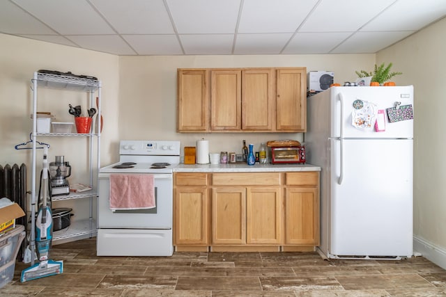 kitchen featuring light countertops, white appliances, wood finish floors, and a drop ceiling