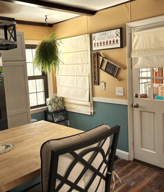 dining area featuring dark wood-type flooring and a wainscoted wall