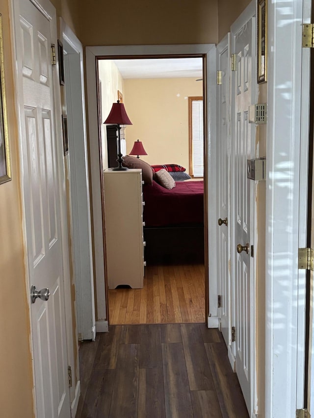 corridor featuring dark wood finished floors