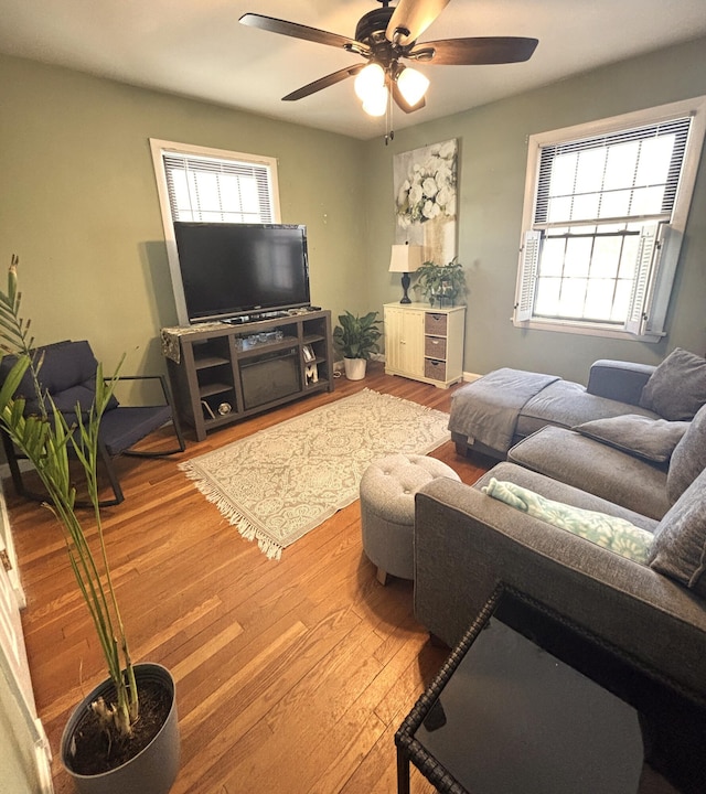 living room featuring wood finished floors, a wealth of natural light, and a ceiling fan