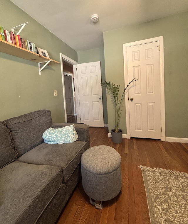 living area featuring dark wood-style flooring and baseboards