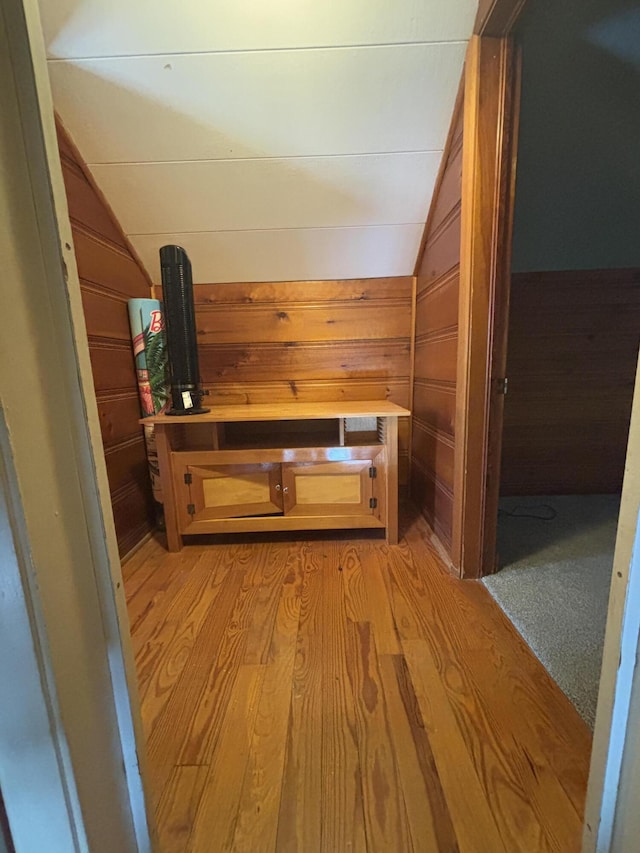 interior space with lofted ceiling, wood walls, and light wood-style flooring