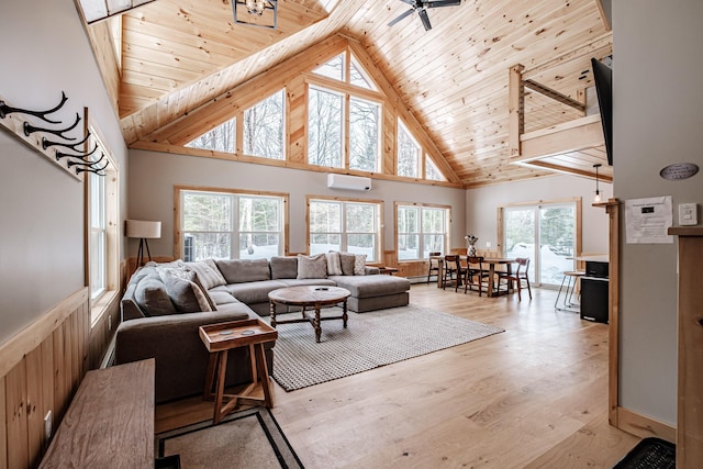 living area featuring high vaulted ceiling, a wall mounted air conditioner, wooden ceiling, and light wood-style floors