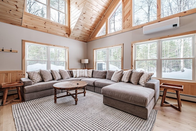 living room with a healthy amount of sunlight, a wall unit AC, light wood-style flooring, and wainscoting