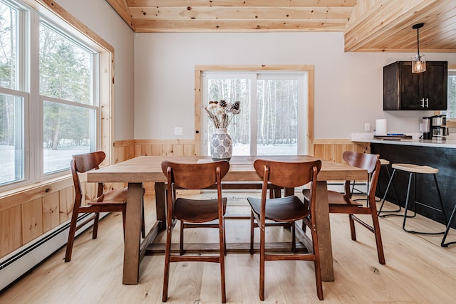 dining room featuring a baseboard radiator, wainscoting, and light wood-style flooring