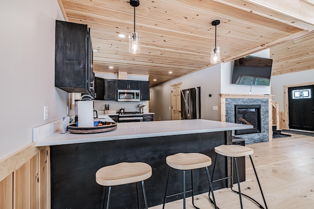 kitchen featuring light countertops, appliances with stainless steel finishes, a peninsula, and wood ceiling