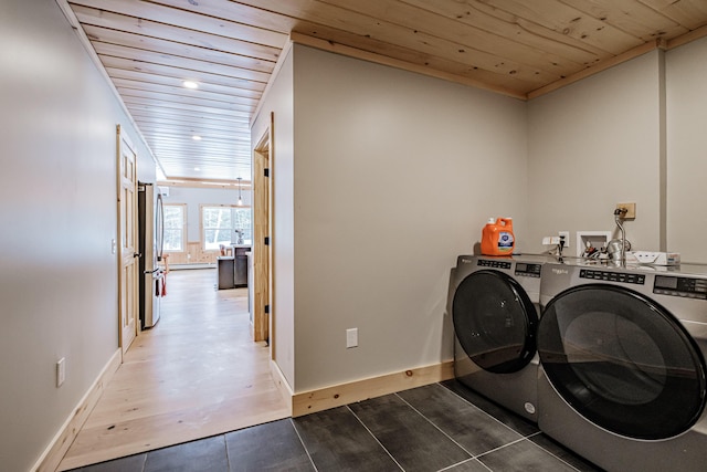 laundry room featuring laundry area, baseboards, wood ceiling, wood finished floors, and washing machine and clothes dryer