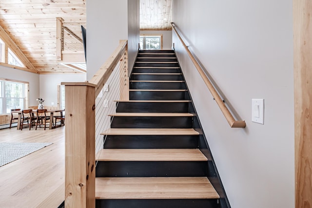 staircase with high vaulted ceiling, wood ceiling, and wood finished floors