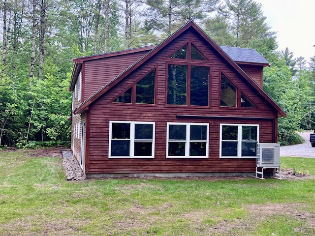 view of side of home featuring ac unit and a yard