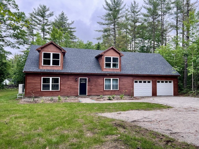 view of front of property with a garage, gravel driveway, roof with shingles, and a front lawn