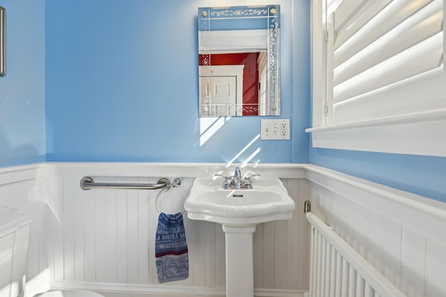 bathroom featuring a wainscoted wall and a sink