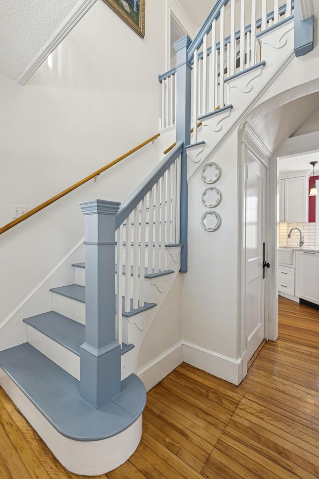 stairway with baseboards and wood finished floors