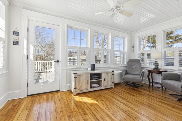 sunroom with ceiling fan and radiator