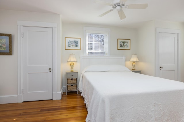 bedroom featuring a ceiling fan, baseboards, and wood finished floors