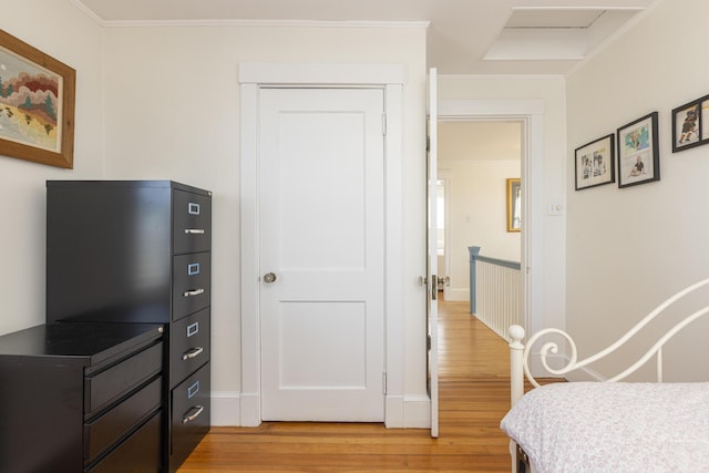 bedroom featuring light wood-type flooring and crown molding