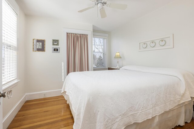 bedroom featuring ceiling fan, baseboards, and wood finished floors