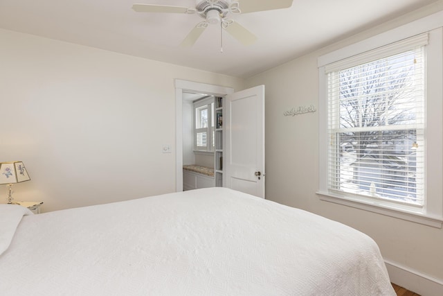 bedroom with multiple windows, ceiling fan, and baseboards