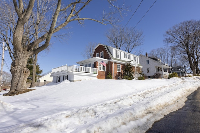 view of front facade with brick siding and a gambrel roof