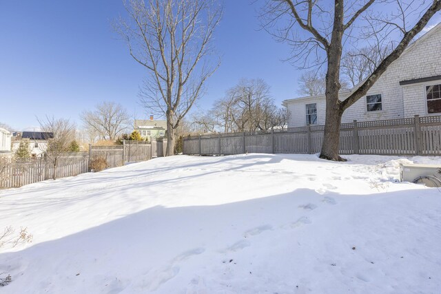 snowy yard featuring a fenced backyard