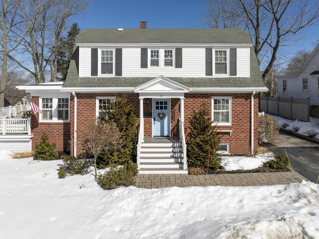 view of front of house featuring a shingled roof and brick siding