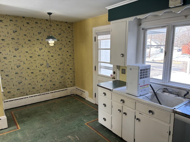 kitchen with wallpapered walls, baseboards, white cabinets, hanging light fixtures, and baseboard heating