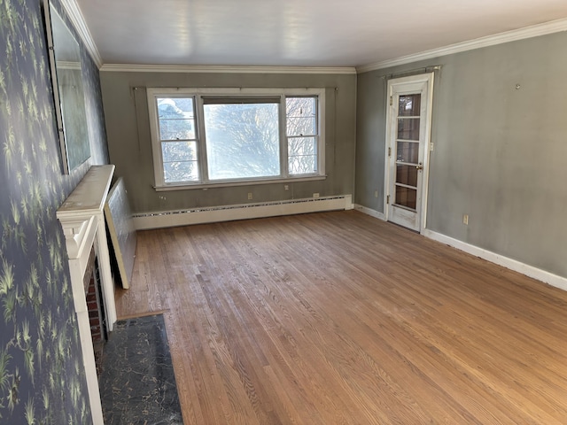 unfurnished living room featuring a baseboard heating unit, baseboards, wood finished floors, and crown molding