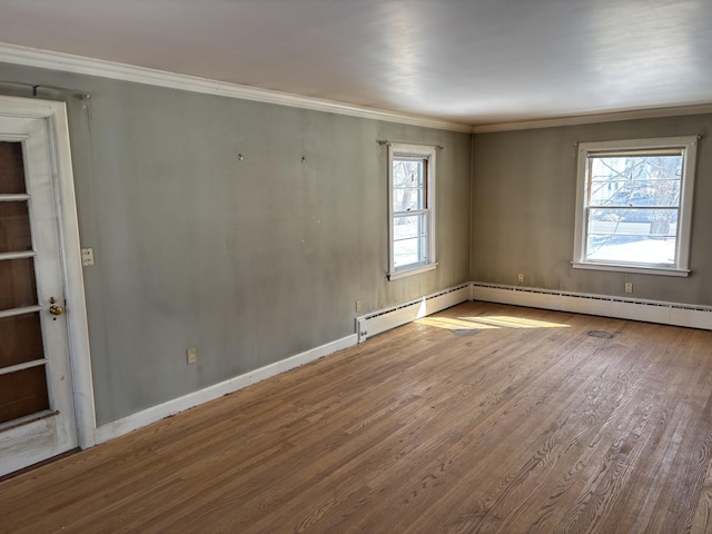 unfurnished room featuring ornamental molding, baseboard heating, wood finished floors, and baseboards