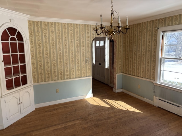 unfurnished dining area featuring wood finished floors, a wealth of natural light, and wallpapered walls