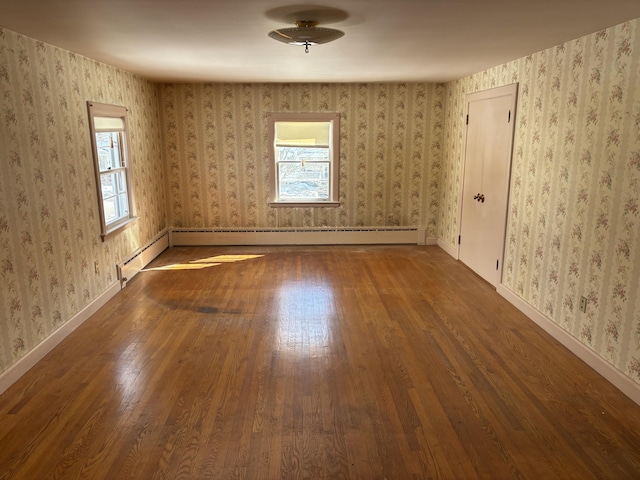 spare room with a healthy amount of sunlight, wallpapered walls, and wood finished floors