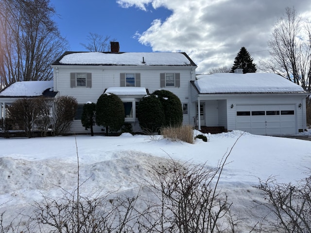 traditional-style home featuring a chimney and an attached garage