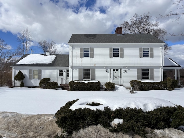 colonial-style house featuring a chimney