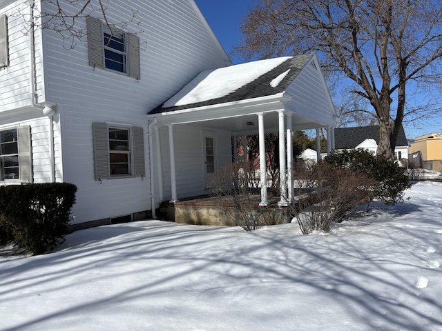 snow covered property featuring a carport