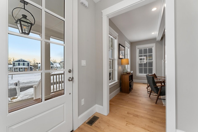 doorway to outside featuring baseboards, recessed lighting, visible vents, and light wood-style floors