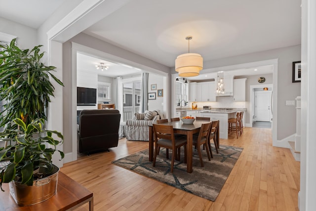 dining area with light wood-style flooring and baseboards