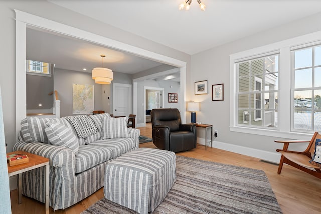 living room with plenty of natural light, baseboards, and wood finished floors