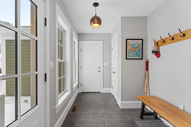 mudroom with dark tile patterned flooring, visible vents, and baseboards