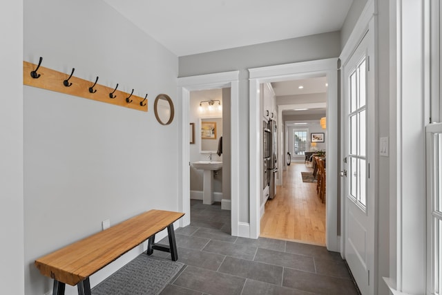 mudroom featuring baseboards and dark tile patterned flooring