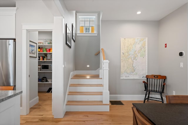 staircase featuring recessed lighting, baseboards, and wood finished floors