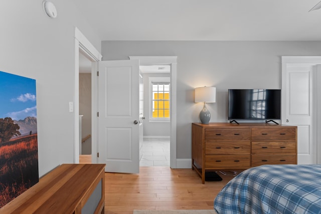 bedroom featuring light wood-style floors and baseboards