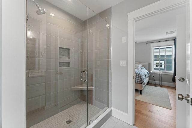 ensuite bathroom with a stall shower, visible vents, connected bathroom, and baseboards