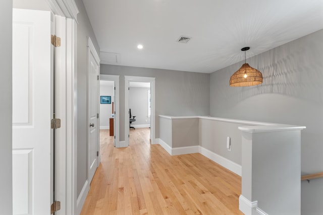 corridor with light wood finished floors, visible vents, baseboards, and recessed lighting