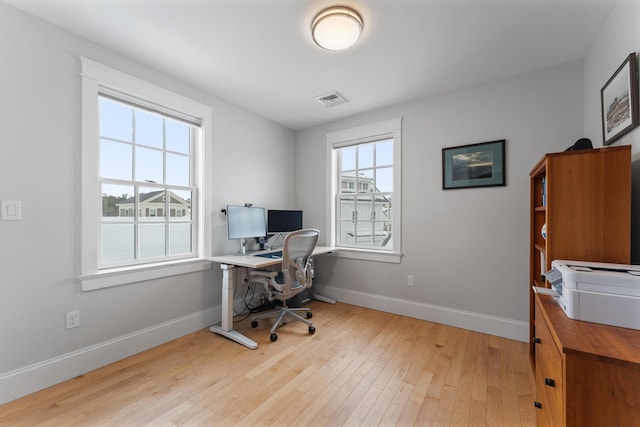 office featuring light wood-style flooring, visible vents, and baseboards