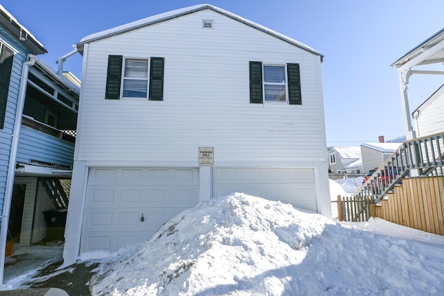 view of front of home featuring fence and an attached garage