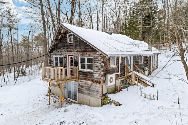 snow covered structure featuring a garage and stairway