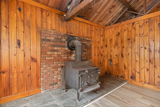 interior details with a wood stove, wood ceiling, wooden walls, and beam ceiling