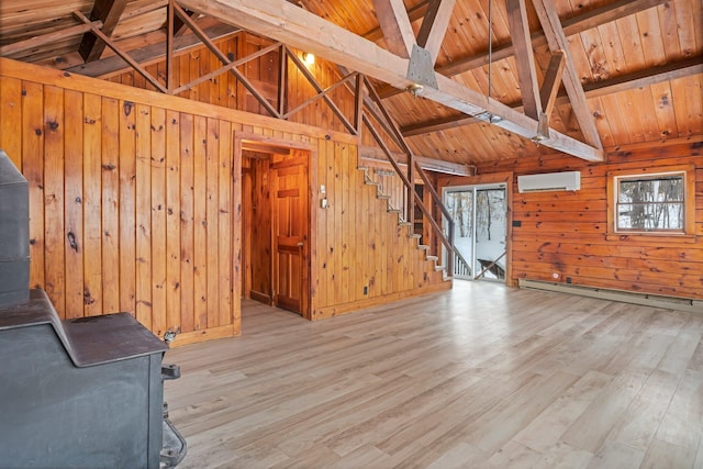 interior space with a wood stove, wooden ceiling, an AC wall unit, and wood finished floors