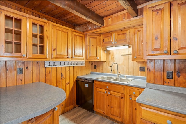 kitchen featuring black dishwasher, a sink, wooden walls, wooden ceiling, and beamed ceiling