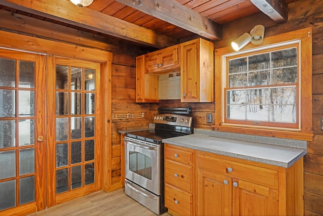 kitchen featuring beam ceiling, wood walls, stainless steel range with electric stovetop, light wood-type flooring, and wooden ceiling