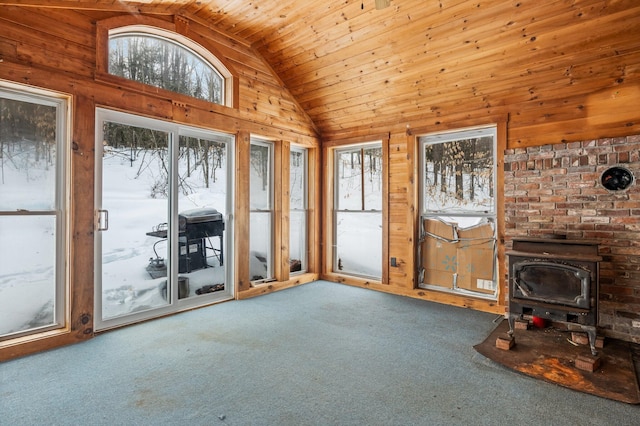 unfurnished living room featuring carpet, lofted ceiling, a wood stove, wood walls, and wooden ceiling